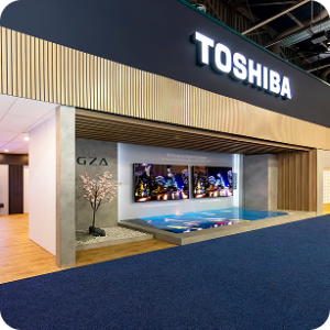A modern exhibition booth at CES AV production with a large "TOSHIBA" sign, featuring a sleek wooden and concrete design, video screens, a small indoor pool, and a decorative plant on display.