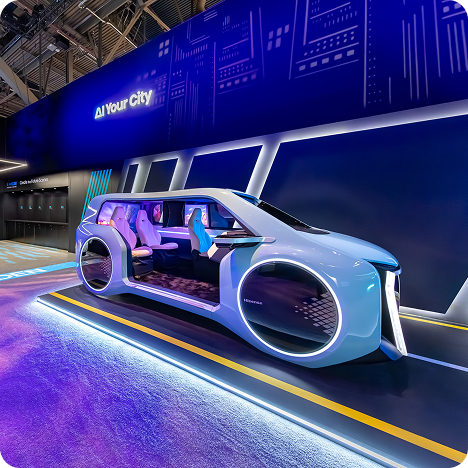 A futuristic concept car with large circular wheels and an open side is showcased in a modern, high-tech exhibit space with blue and purple lighting, evoking the innovation of CES AV production. The interior features sleek, minimalist seats and digital panels.